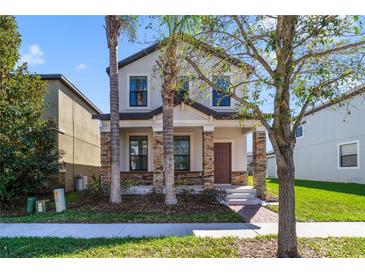 Charming two-story home with stone accents on the front porch pillars and a manicured front lawn at 15088 Night Heron Dr, Winter Garden, FL 34787