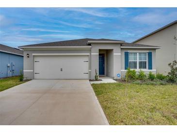 Charming single story home with a two car garage, manicured lawn, and blue shutters at 1750 Eagle Hammock Blvd, Eagle Lake, FL 33839