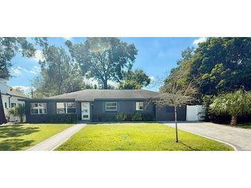 Charming single-story home with a well-maintained lawn, featuring a dark exterior and bright white trim at 2812 Mulford Ave, Winter Park, FL 32789