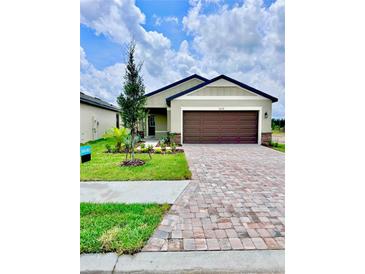 Charming single-Gathering home featuring a brick driveway, two-car garage, and well-manicured lawn at 3219 Cup Dr, Lakeland, FL 33803