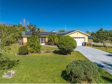 Charming yellow home with solar panels, landscaped yard and a long driveway at 401 Cart Ct, Kissimmee, FL 34759
