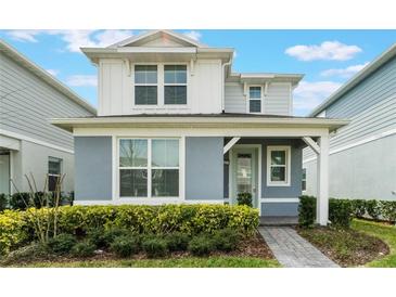 Charming two-story home with a covered entry and lush landscaping at 14218 Lanikai Beach Dr, Orlando, FL 32827