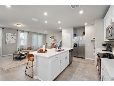 Bright, open-concept kitchen features a spacious island, stainless steel appliances, and seamless flow into the living area at 2052 Milkweed St, Ocoee, FL 34761
