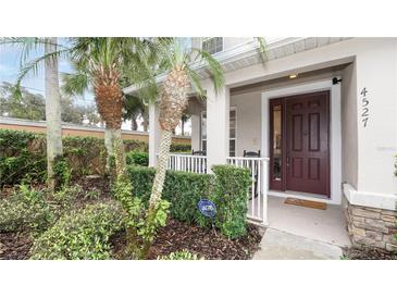 Inviting home entrance featuring a charming porch, lush landscaping, and a secure ADT system at 4527 Sunset Ln, Oviedo, FL 32765