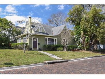 Charming two-story home with a well-maintained lawn, stone walkway, and attractive landscaping at 501 Sheridan Blvd, Orlando, FL 32804