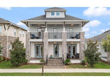 Two-story home featuring stone accents, double porches, and a well-manicured lawn at 8852 Sperry St, Orlando, FL 32827
