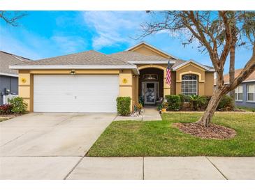 Charming single-story home with a well-manicured lawn and a two-car garage at 130 Bloomingdale Dr, Davenport, FL 33897