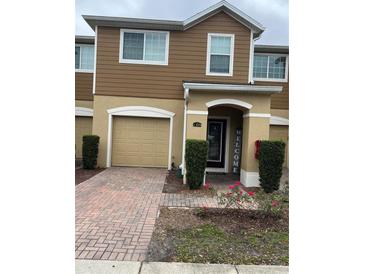 Charming townhome featuring a brick paved drive, attached garage, and a welcoming entryway at 1309 Heritage Commons Dr, Winter Springs, FL 32708