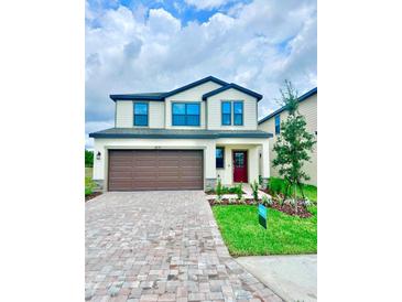 Charming two-story home with a manicured lawn, brick driveway and a two car garage at 3171 Cup Dr, Lakeland, FL 33803