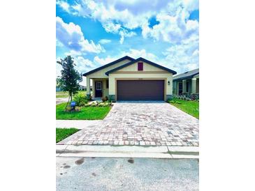 A charming single-story home with a brick paver driveway and well-manicured lawn at 3225 Cup Dr, Lakeland, FL 33803
