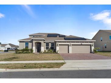 Charming home with three-car garage and a welcoming front entrance, enhanced by professional landscaping at 4897 Gilded Jewel Dr, Mount Dora, FL 32757