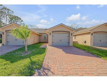 Charming single-story villa with a brick driveway and well-maintained landscaping at 114 Tuscany Villas Dr, Edgewater, FL 32141