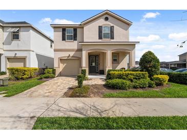 Charming home with a well-maintained lawn and inviting covered front porch at 1841 Sawyer Palm Pl, Kissimmee, FL 34747