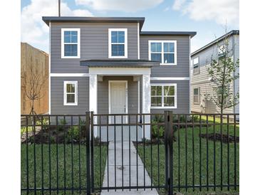 Charming two-story home with a well-manicured lawn and a black metal fence at 2455 Zuni Rd, St Cloud, FL 34771