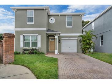 Charming home with a brick-paved driveway, well-maintained lawn, and an attached one-car garage at 5852 Mariposa Cove Ln, Orlando, FL 32822