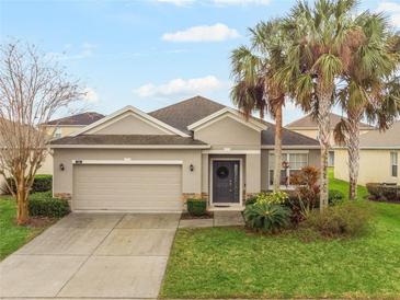 Charming single-story home with a well-manicured lawn and lush landscaping, including beautiful palm trees at 105 Adoncia Way, Sanford, FL 32771