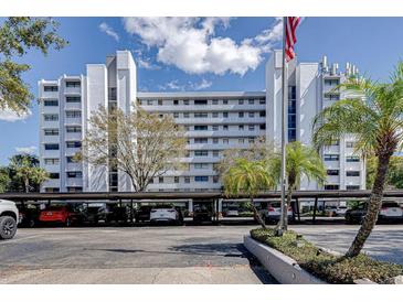 Exterior shot of condo building featuring covered parking, landscaping, and an American flag at 1100 S Orlando Ave # 301, Maitland, FL 32751