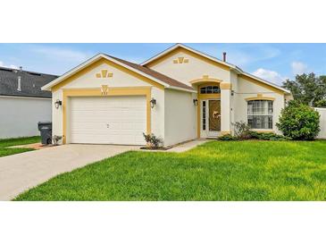 Charming single-story home with a well-manicured lawn, complemented by a two-car garage and yellow trim at 131 Sonja Cir # 1, Davenport, FL 33897