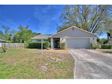 Charming single-story home with a well-maintained lawn and a two-car garage at 16 Cedar Dr, Davenport, FL 33837