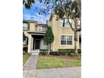 Inviting two-story townhome featuring well-maintained landscaping and neutral color palette at 7681 Fordson Ln, Windermere, FL 34786