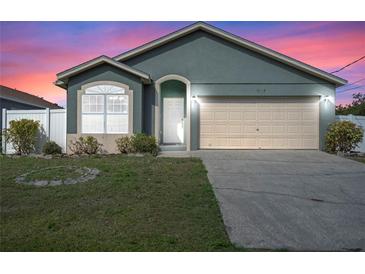 Charming one-story home featuring a two-car garage and well-maintained front lawn at dusk at 8519 Rainbow Ave, Orlando, FL 32825