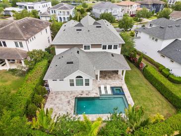 Stunning backyard view features a sparkling pool, spa, travertine patio, and lush landscaping at 9454 Becker Ct, Orlando, FL 32827