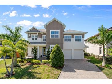 Charming two-story home boasts lush landscaping, a paver driveway, and a welcoming front porch at 9454 Becker Ct, Orlando, FL 32827