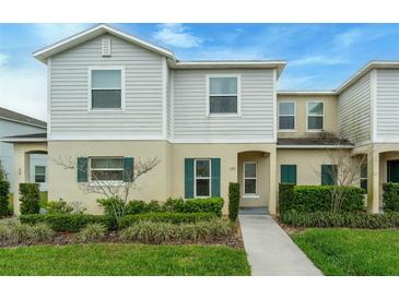 Charming two-story home with a well-manicured lawn and landscaped garden and welcoming front entrance at 157 Primrose Dr, Davenport, FL 33837