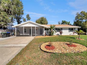 Charming single-story home with a screened-in porch, well-manicured lawn, and stone accents at 5825 Hafer Ln, Orlando, FL 32808