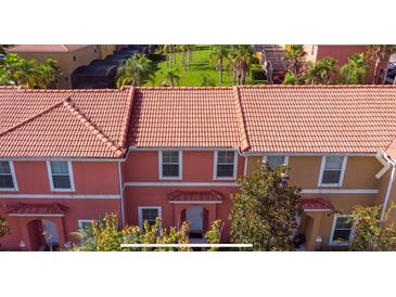 Townhomes with terra cotta tile roofs, colorful facades and tropical landscaping provide a lovely curb appeal at 3008 Secret Lake Dr, Kissimmee, FL 34747