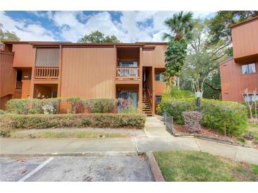 Two-story condo with a balcony, a palm tree in the front yard, and a well-maintained landscaped exterior at 1038 E Michigan St # B, Orlando, FL 32806