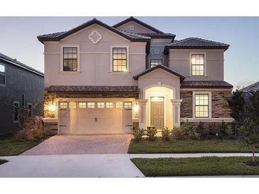 Charming two-story home with a two-car garage, stone accents, and manicured landscaping at 1454 Belle Terre Rd, Davenport, FL 33896