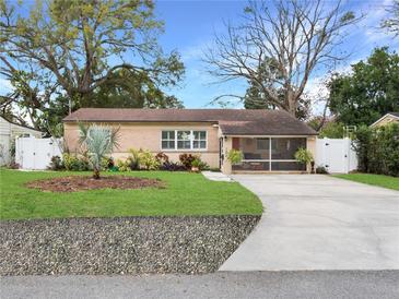 Charming single-story home featuring a well-manicured front yard and screened front porch, creating an inviting curb appeal at 1632 Pinewood Dr, Orlando, FL 32804