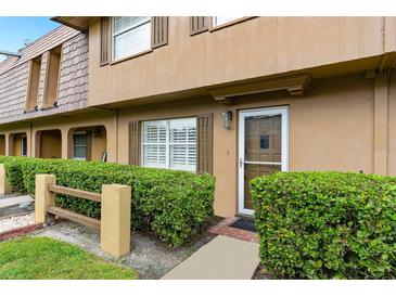 Charming condo entrance featuring a well-manicured lawn, neutral exterior paint, and classic shuttered windows at 3104 Harrison Ave # A6, Orlando, FL 32804