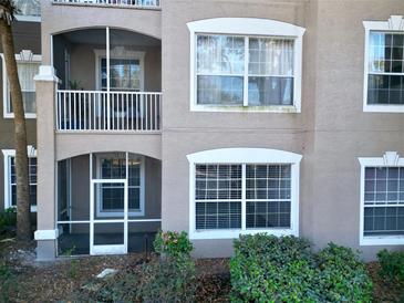 The exterior features a screened porch and balcony with white railings and beige walls at 7147 Yacht Basin Ave # 115, Orlando, FL 32835