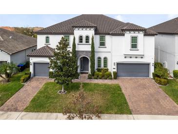 Stately two-story home featuring a manicured lawn, gray roof, and two-car garage at 8390 Ludington Cir, Orlando, FL 32836