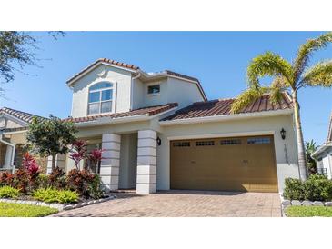 Charming two-story home features a well-maintained lawn, lush landscaping, and a terracotta tile roof at 10209 Henbury St, Orlando, FL 32832