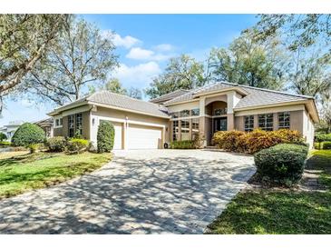A beautifully landscaped home with a paver driveway and a neutral color palette at 1203 Gatwick Loop, Lake Mary, FL 32746