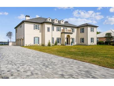 Stunning home with a beautiful lawn, long driveway, and lovely architectural details at 30215 Island Club Dr, Deer Island, FL 32778