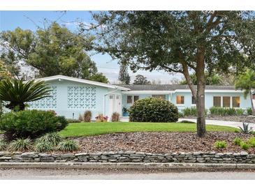Charming single-story home boasts a well-manicured lawn, mature trees, and stylish mid-century modern architectural features at 625 Worthington Dr, Winter Park, FL 32789