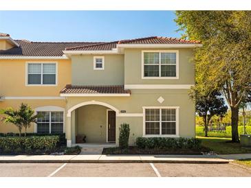 Inviting townhome featuring a red tile roof, arched entry, and tidy landscaping at 8990 Cuban Palm Rd, Kissimmee, FL 34747