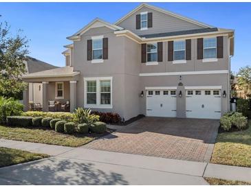 Charming two-story home featuring a three-car garage, covered porch, and well-maintained landscaping at 16310 Rock Coast Dr, Winter Garden, FL 34787