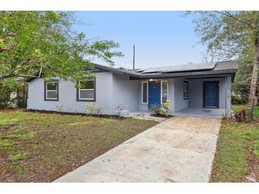 Charming single-story house featuring a gray exterior, solar panels, and a well-maintained front yard at 1834 Willie Mays Pkwy, Orlando, FL 32811
