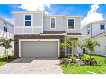 Beautiful two-story home with stone accents, well-manicured lawn, and a spacious two-car garage at 3432 Lilac Way, Davenport, FL 33897