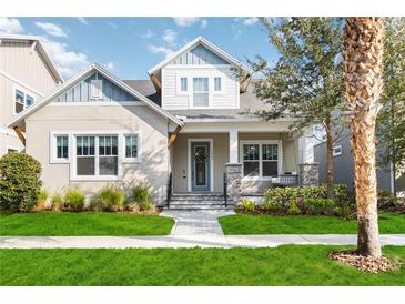 Charming two-story home featuring a landscaped front yard and welcoming front porch with swing at 7845 Dausset St, Orlando, FL 32827