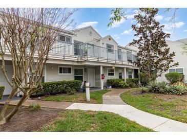 Inviting exterior view of condo featuring a balcony, well-maintained landscaping, and a charming walkway at 2552 Woodgate Blvd # 204, Orlando, FL 32822