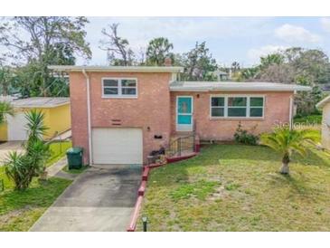 Charming single-story brick home with a well-maintained lawn, garage, and inviting blue front door at 256 Morningside Ave, Daytona Beach, FL 32118