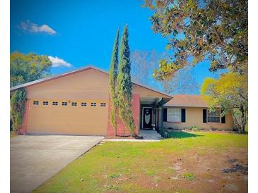 Charming single-story home with a well-manicured lawn and a spacious two-car garage at 1002 Royalton Rd, Orlando, FL 32825