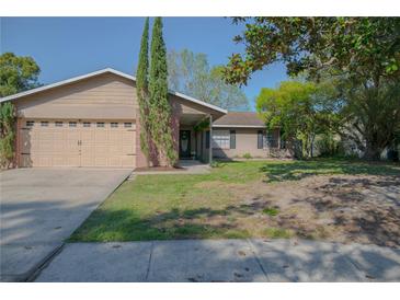 Charming single-story home features a well-maintained lawn, two-car garage and mature landscaping at 1002 Royalton Rd, Orlando, FL 32825