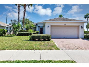 Charming single-story home featuring a two-car garage, manicured lawn, and inviting curb appeal at 1306 Windward Oaks Loop, Auburndale, FL 33823